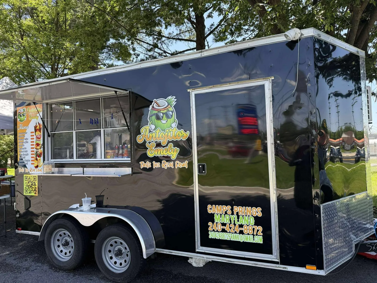 Antojitos Emely food trailer, serving window open, colorful fruit-themed wrap