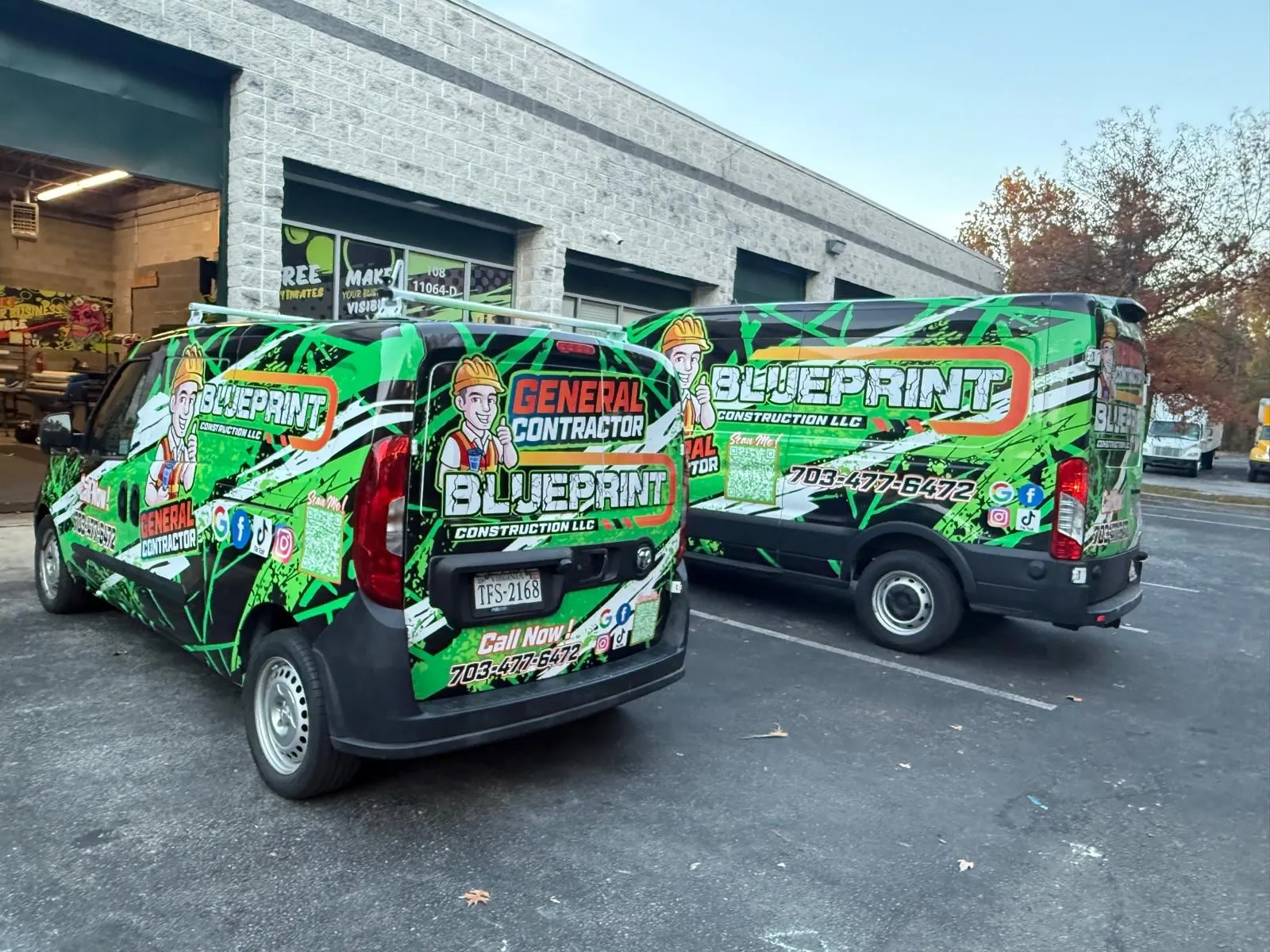 Two Blueprint Construction LLC vans with green and red wrap, parked side by side