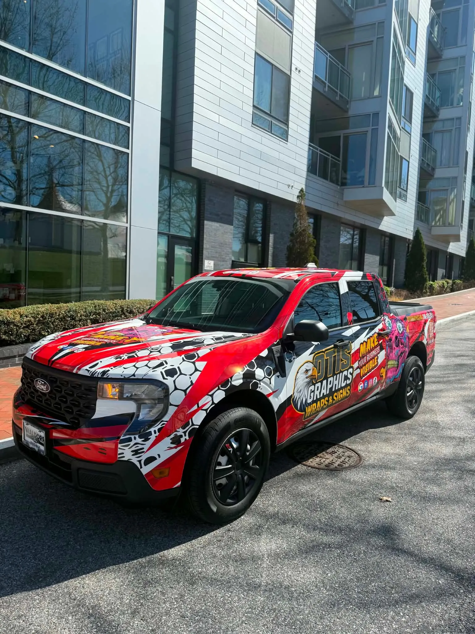 Otis Graphics Wraps and Signs demo pickup truck with red paint-splash wrap