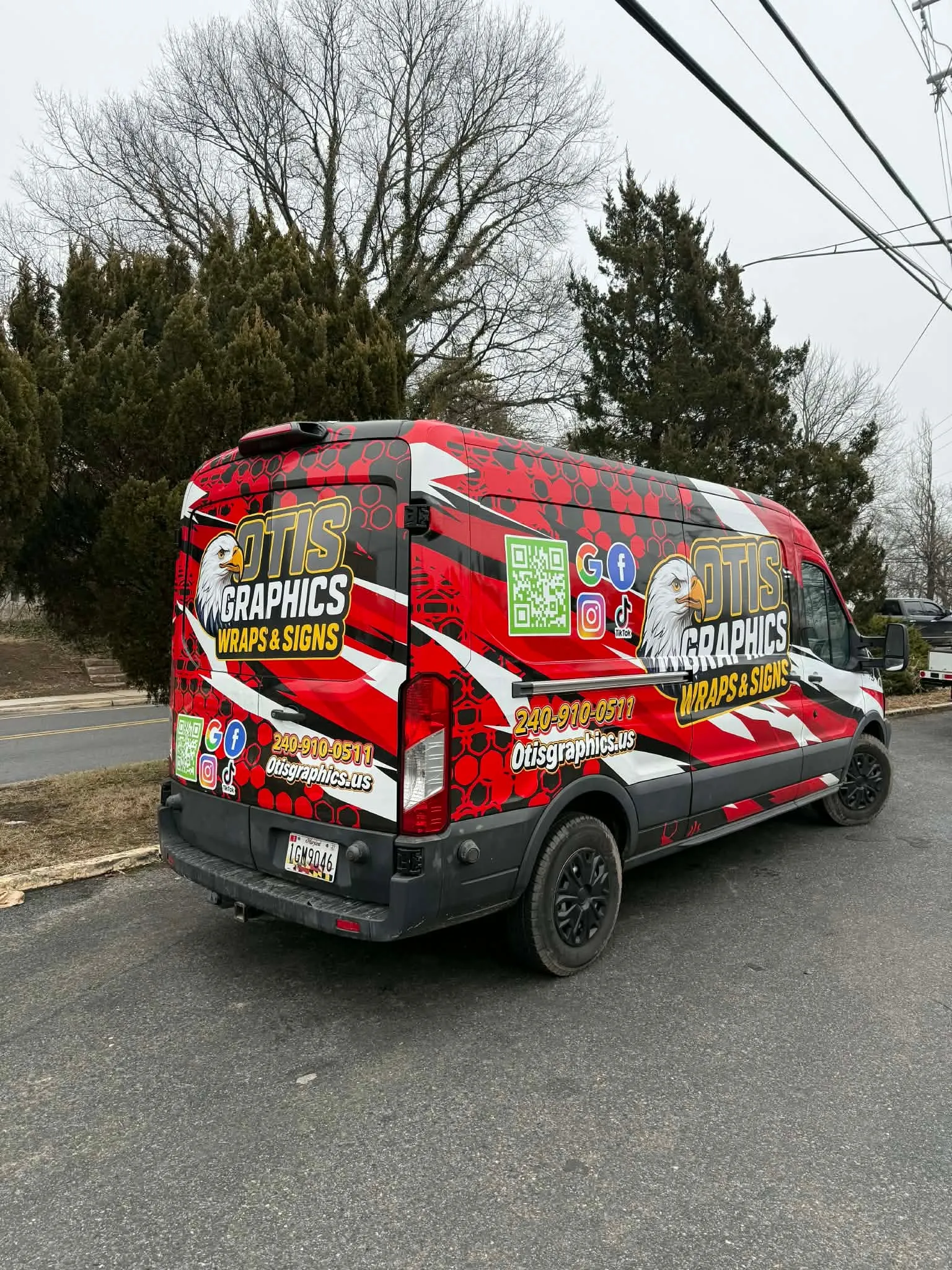 Otis Graphics Wraps and Signs demo van with red paint-splash wrap
