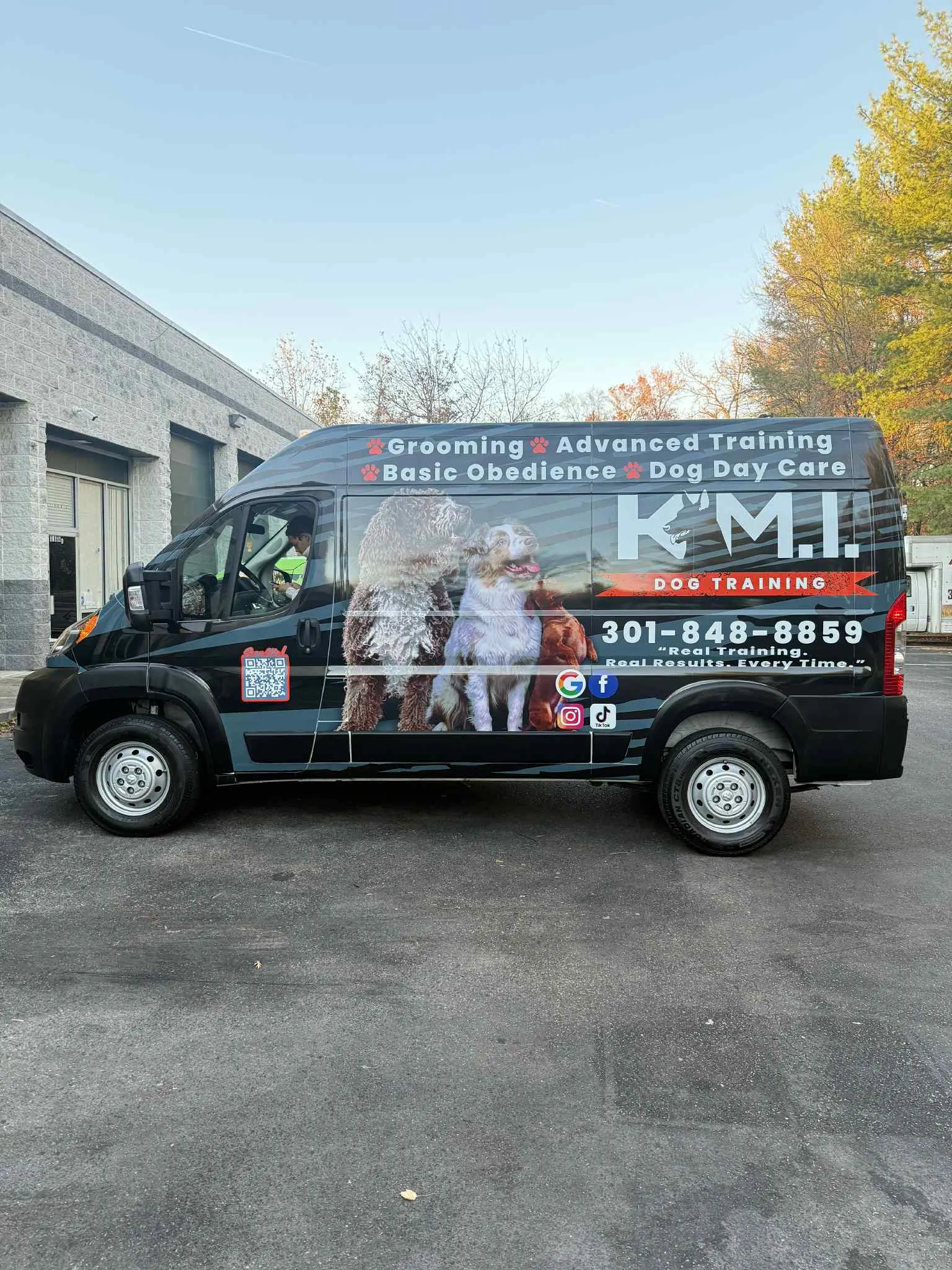 Black full vehicle wrap on a pet training and grooming service van